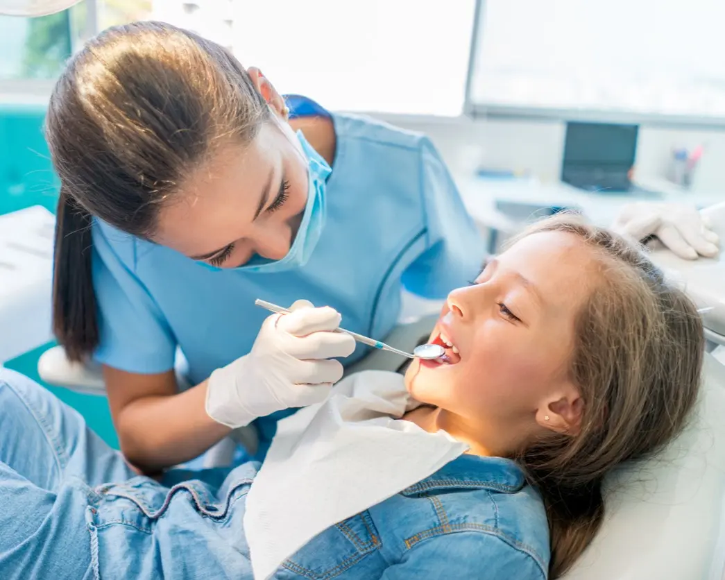 Dentysta robi przegląd zębów małemu dziecku.